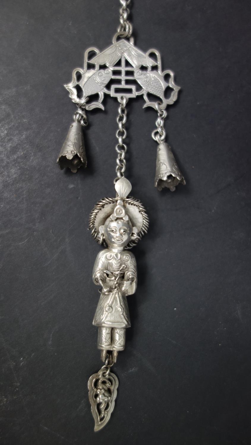 A late 19th century Chinese white metal chatelaine, with bells, pierced fish plaque and figure of - Image 2 of 3