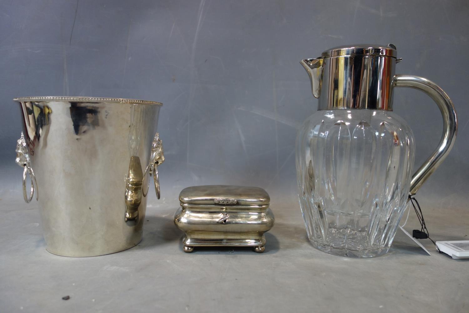 A silver plated ice bucket, casket shaped jewellery box and a cut glass lemonade jug