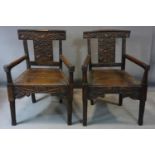 A pair of 18th century oak armchairs, the armrests with carved hands, the back splats with leaves,