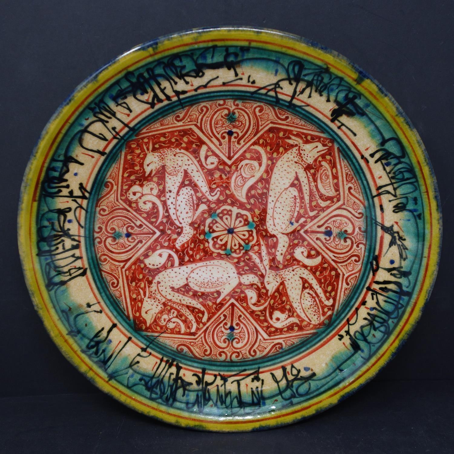 A Persian glazed ceramic plate, decorated with jackals from fables of a Buddhistic source translated