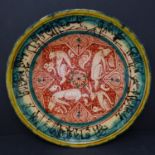 A Persian glazed ceramic plate, decorated with jackals from fables of a Buddhistic source translated