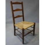 A late 19th / early 20th century ladder back chair, with rush seats, on tapered legs