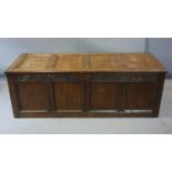 An 18th century oak coffer, of panelled construction, with carved frieze, original lock and fitted