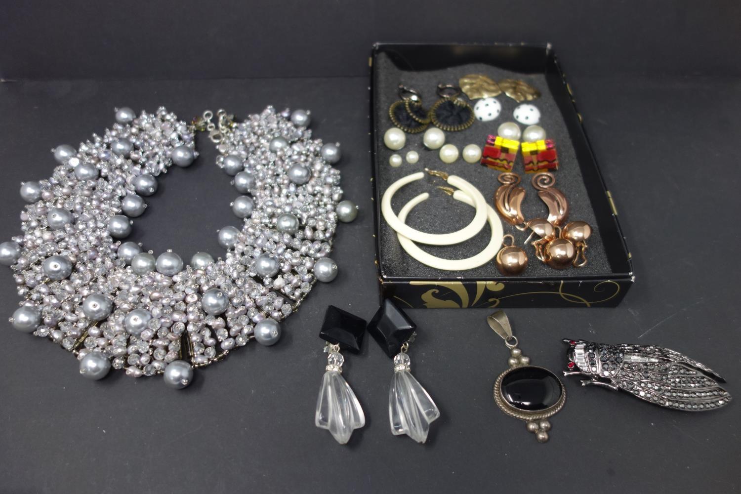 An ornate beaded necklace and a box of earrings, brooch, necklace etc