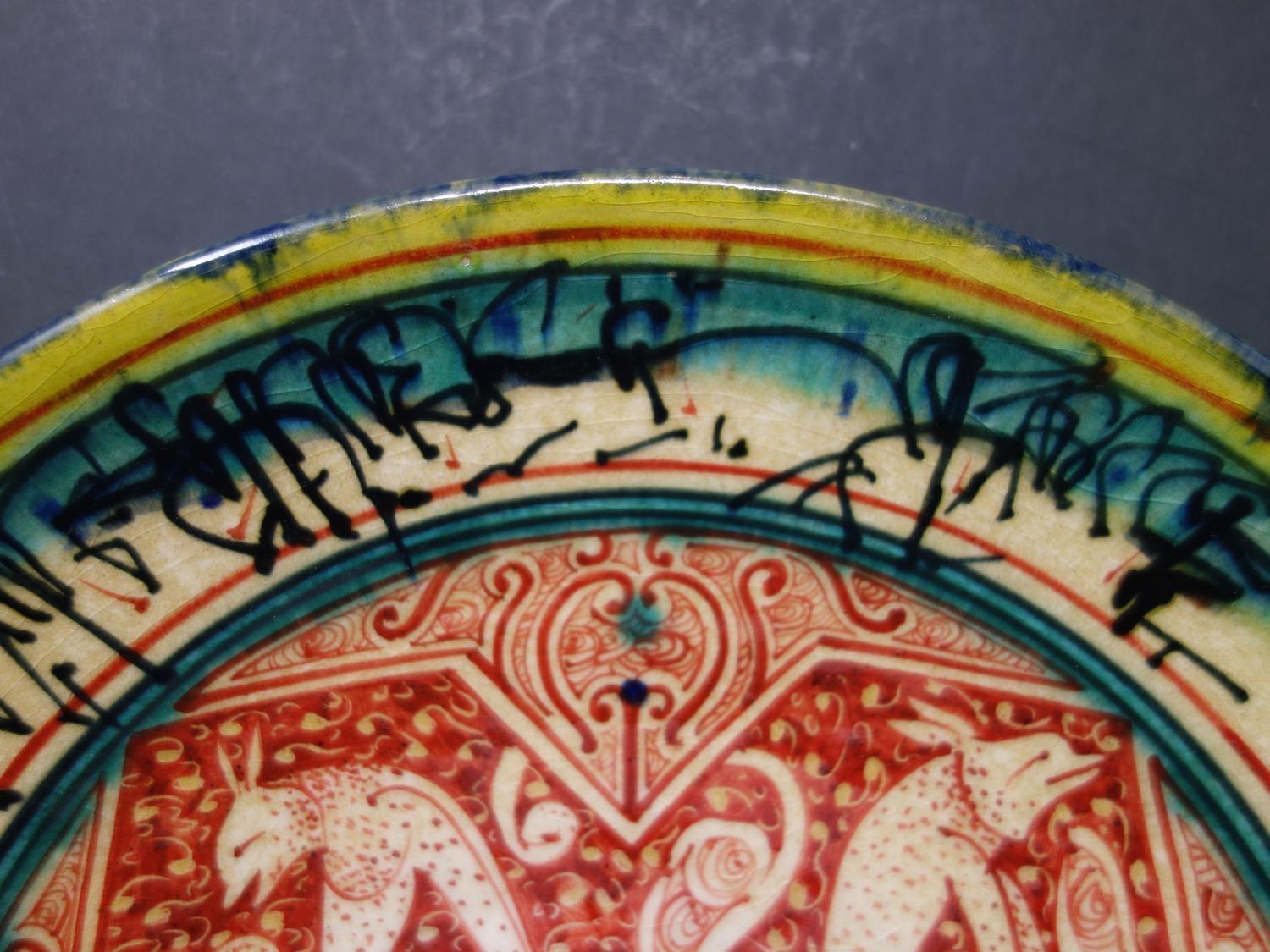 A Persian glazed ceramic plate, decorated with jackals from fables of a Buddhistic source translated - Image 3 of 6