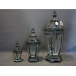 Three storm lanterns of graduating size, tallest H.79cm, one glass panel broken to tallest lantern