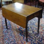 A 19th century mahogany drop flap Pembroke table on ring turned supports, with single short