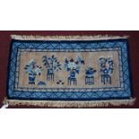 A 20th century Chinese blue and white woolen rug with vase of flowers design, 140 x 73cm