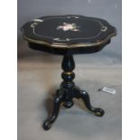 An ebonised centre table with scalloped rim, having central floral decoration, raised on baluster