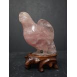 A Chinese carved rose quartz bird on a hardwood stand 85 mm in height, 20th century.