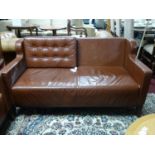 A brown leather 2 seater sofa, with button back cushions on tapered legs, H.80 W.153 D.73cm