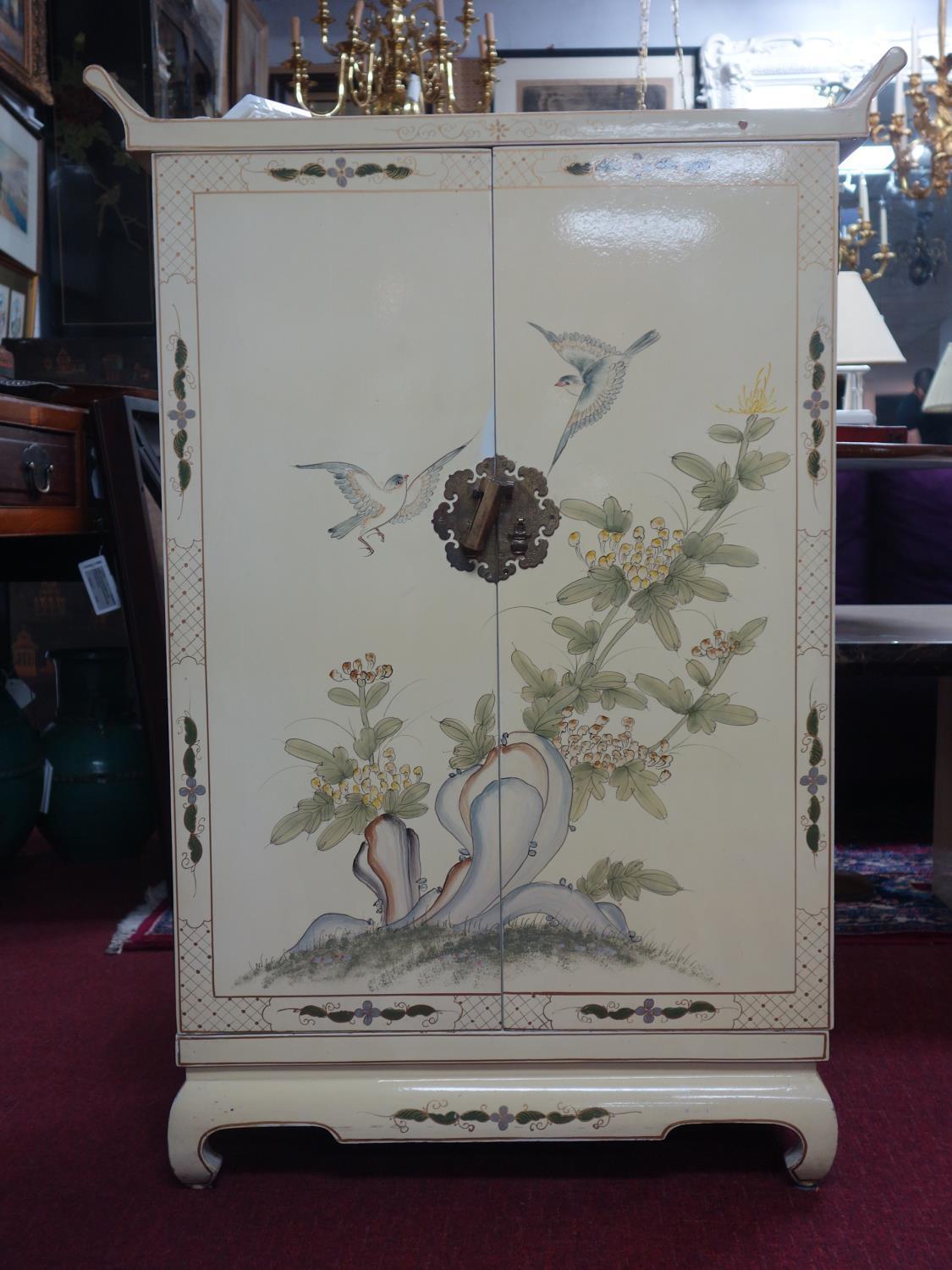 A Chinese cream lacquered cabinet, decorated with birds and flowers, with two cupboard doors above