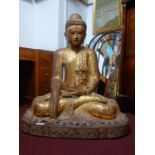 A large Burmese gilt wood seated Buddha, with coloured glass detailing, H.112 W.90cm