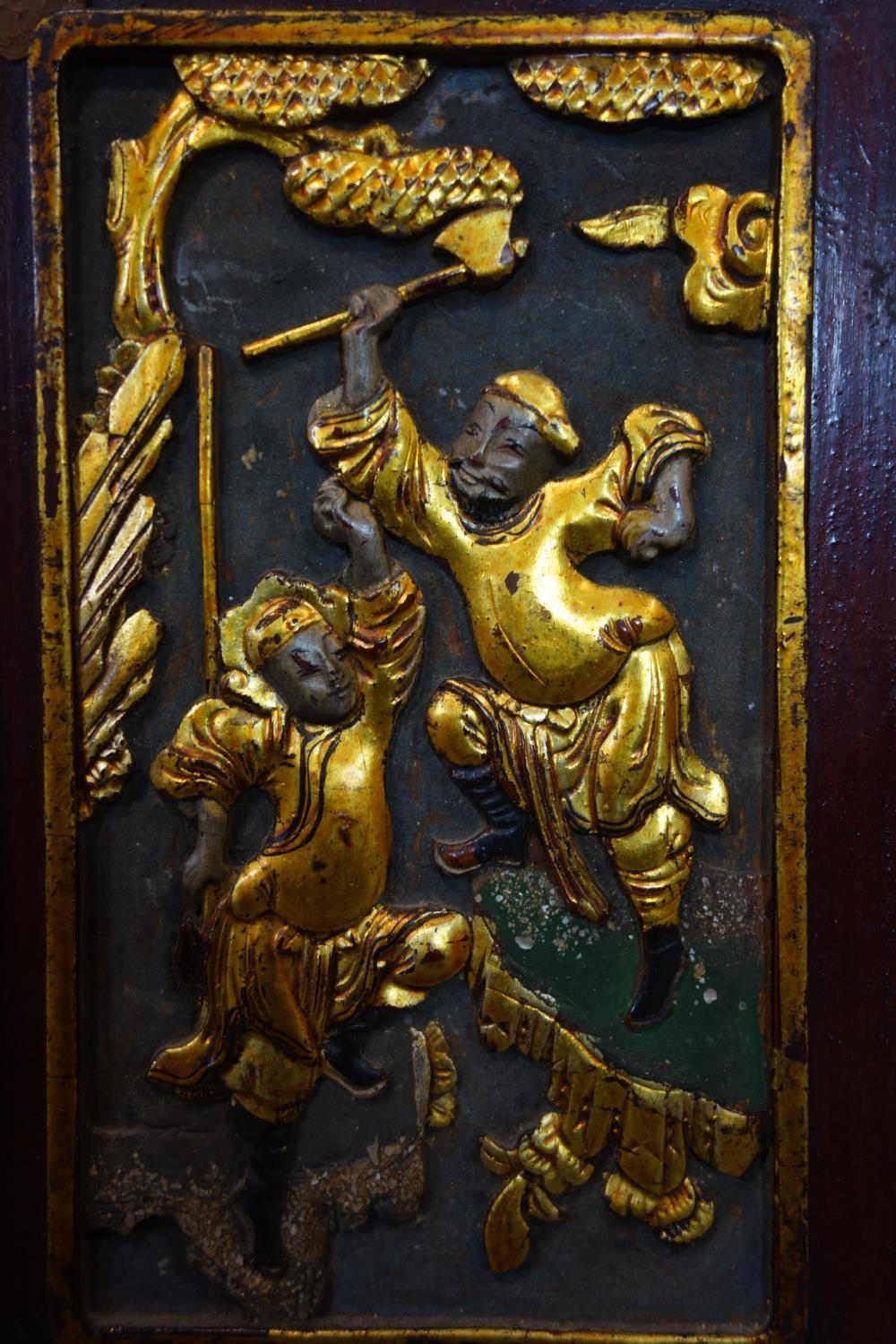 A Chinese carved wood panel, gold lacquer with some colour, of two fighting warriors, 230mm x