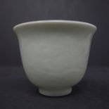 A Chinese white glazed porcelain tea bowl carved phoenix and dragon pattern