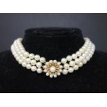 WITHDRAWN A Triple strand white freshwater pearl necklace finished with an 18 carat gold clasp toget