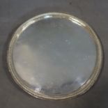 A silver salver with gadrooned edge, raised on three scroll feet, hallmark heavily rubbed, approx.