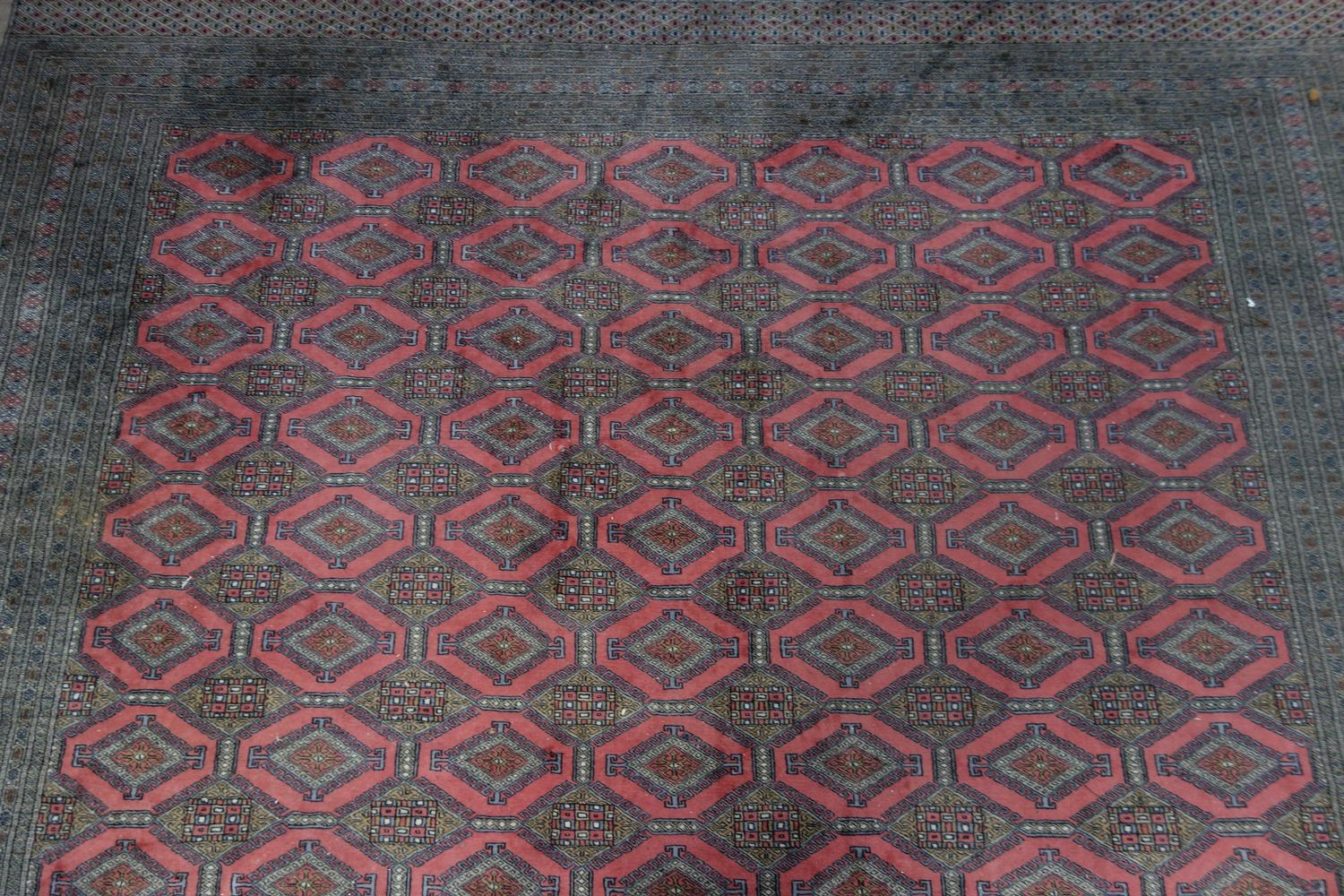 A large 20th century Middle Eastern carpet, with repeating geometric motifs, on a salmon pink - Bild 3 aus 5