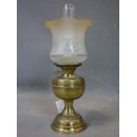 A Victorian brass oil lamp, with glass chimney and frosted peach glass shade etched with Art Nouveau