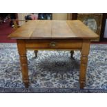 A 20th century kitchen table with fruit wood top and pine base, having single end cutlery drawer,