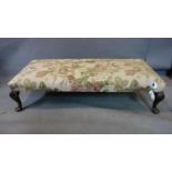 A 20th century footstool with floral linen upholstery, on cabriole legs