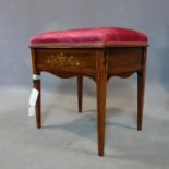 An Edwardian inlaid mahogany piano stool with hinged seat having marquetry inlay depicting urn and
