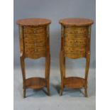 A pair of inlaid walnut bedside chests of three short drawers, gilt metal mounted, raised on