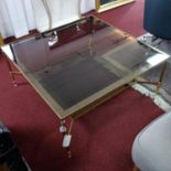 A brass two tier coffee table with smoked glass top on reeded legs, H.46 W.100 D.100cm