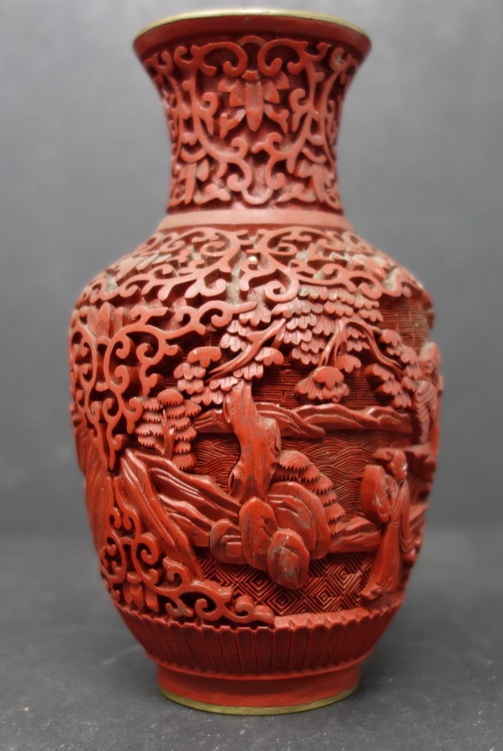 A Chinese cinnabar lacquer vase, decorated in relief with vignettes of figures in landscapes