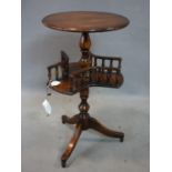 A mahogany lamp table with round top above revolving undertier with turned rails, on three legs