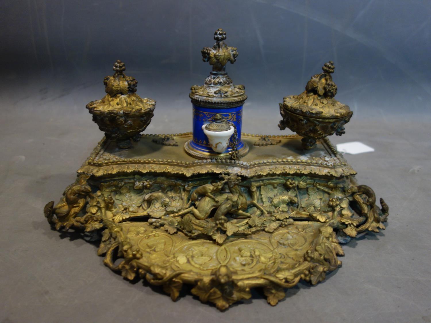 A 19th century French ormolu ink desk stand, with central porcelain pot and applied animals, H.20