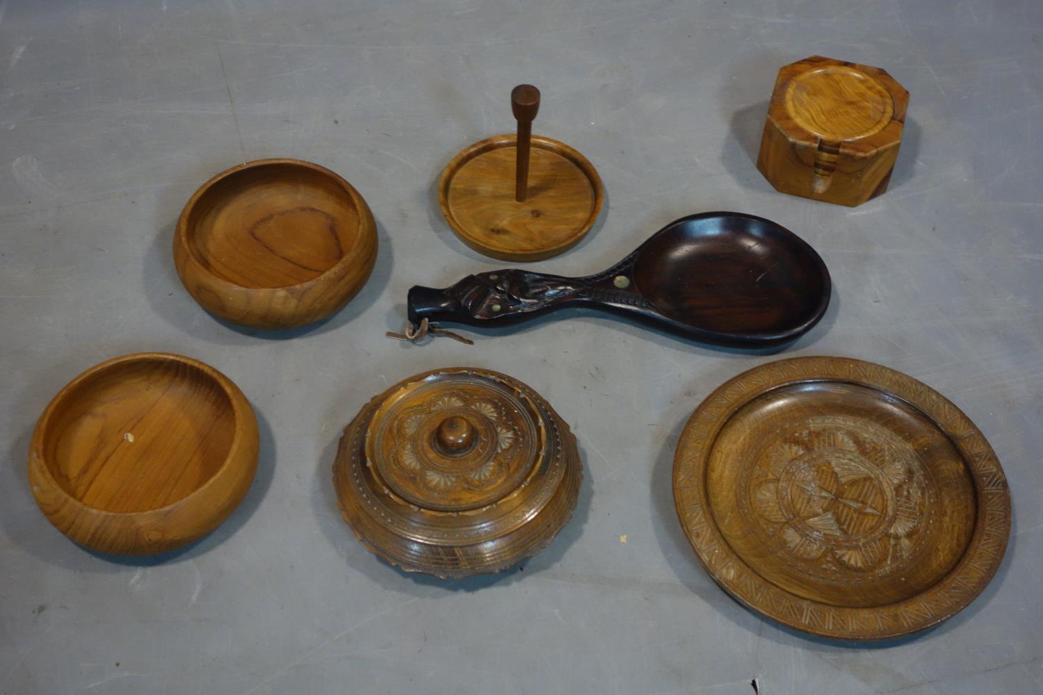 A collection of wooden items, to include a Maori carved spoon inlaid with Paua shell, a plate, a