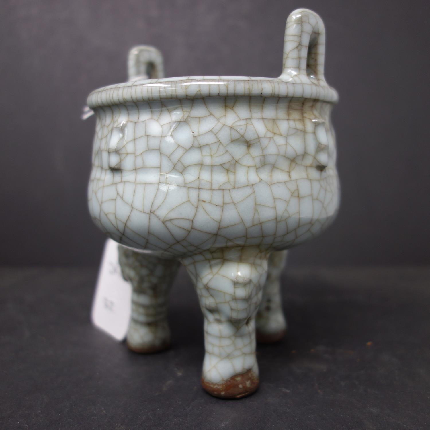 A Chinese celadon crackle glazed twin handled censor, on tripod feet, H.14cm