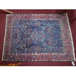 A Persian Kashan rug, having all over floral motifs on a blue ground, within multi floral borders,
