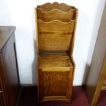 An oak magazine rack, with two division magazine rack above cupboard door, on bracket feet, H.110