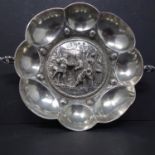 A late 19th century German silver wine taster, of lobed form with the centre repousse embossed