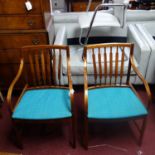 A pair of teak armchairs, with shaped back splats and armrests, having turquoise upholstered seats