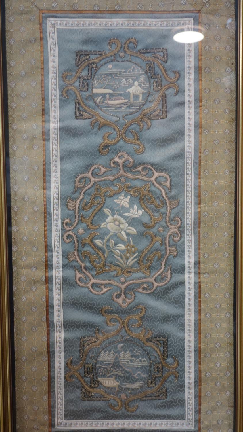 A Chinese embroidered grey green silk panel of a central peony motif and two landscape motifs either