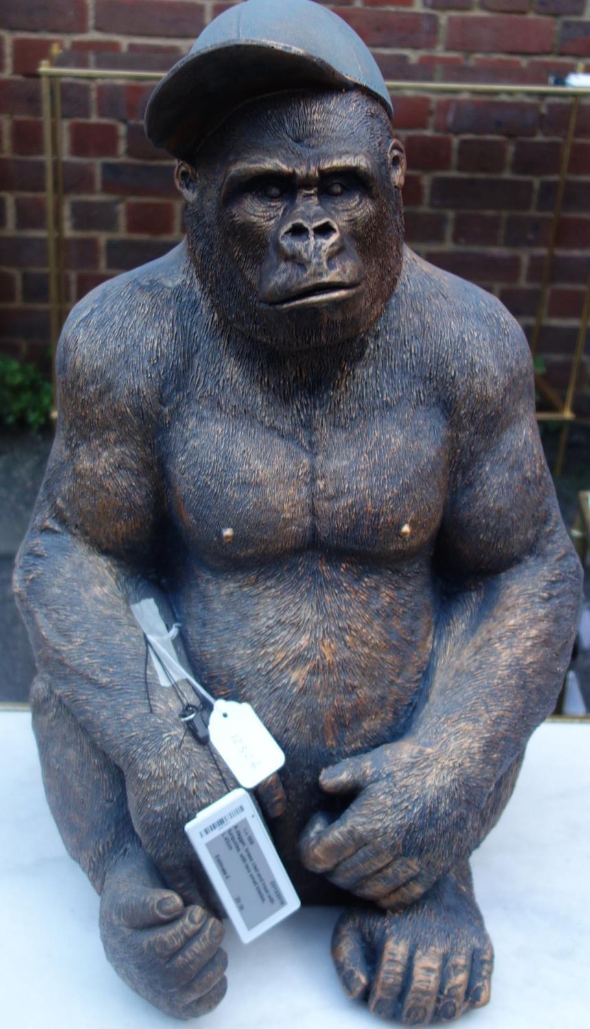 A moulded figure of a seated gorilla wearing a cap, H.60cm