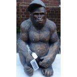 A moulded figure of a seated gorilla wearing a cap, H.60cm