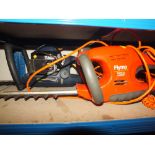 AN ELECTRIC FLYMO EASYCUT HEDGE TRIMMER TOGETHER WITH A PETROL EXAMPLE