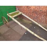 A VINTAGE WOODEN FRAMED TWO CAST WHEELED AGRICULTURAL IMPLEMENT