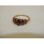 A LADIES HALLMARKED 9CT GOLD FIVE STONE DRESS RING SET WITH RED STONES
