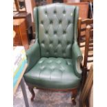 A MODERN UPHOLSTERED GREEN WINGBACK ARMCHAIR