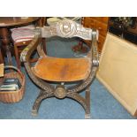 A CARVED OAK LEATHER SEAT CROSS FRAME ARM CHAIR