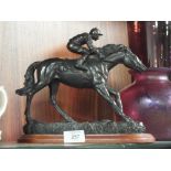 A RESIN FIGURE OF A JOCKEY ON PLINTH