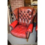 AN OXBLOOD RED WINGBACK LEATHER CHAIR