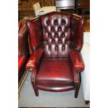 AN OXBLOOD RED WINGBACK LEATHER CHAIR