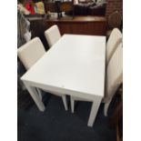 A MODERN WHITE EXTENDING DINING TABLE TOGETHER WITH FOUR FABRIC COVERED CHAIRS