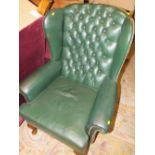 A GREEN LEATHER WINGBACK ARMCHAIR